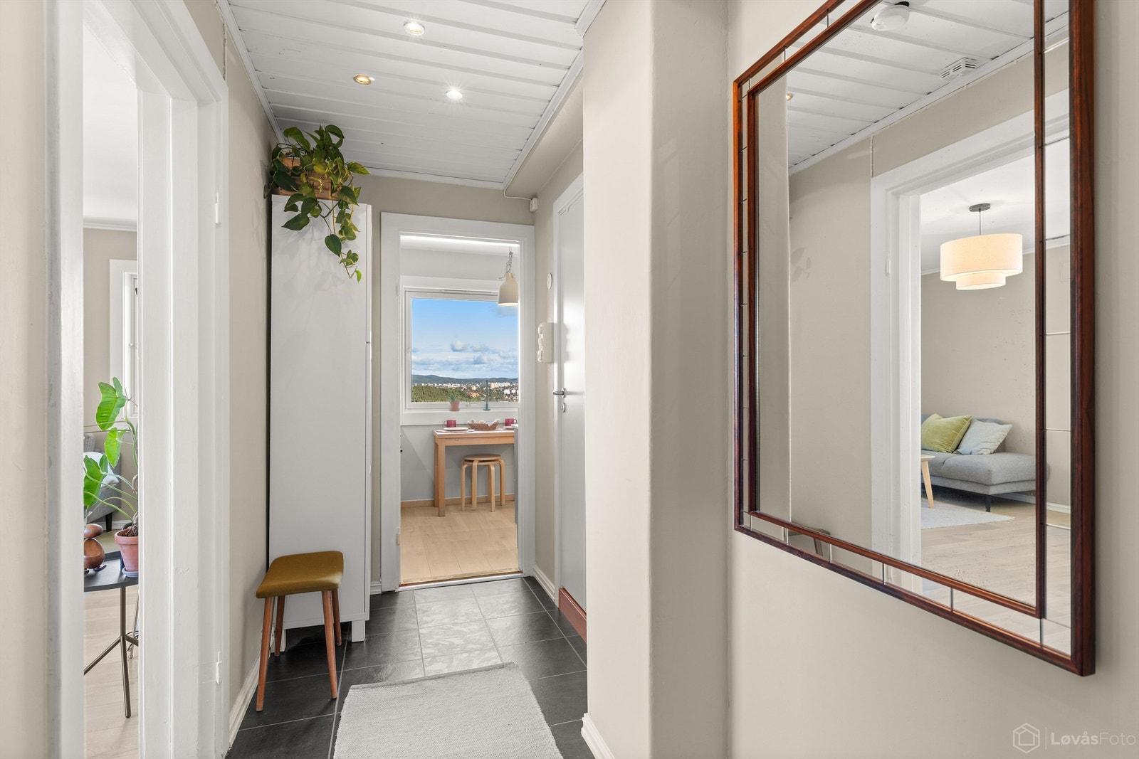 En lys og innbydende entré med moderne overflater, downlights og garderobeskap. Entréen fungerer samtidig som et naturlig og funksjonelt bindeledd mellom boligens øvrige rom. Galleribilde