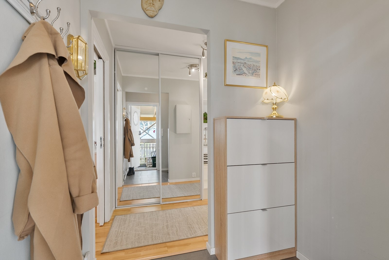 Velkommen inn! Innbydende entré med flislagt gulv og varmekabler, videre er det skyvedørsgarderobe. Galleribilde