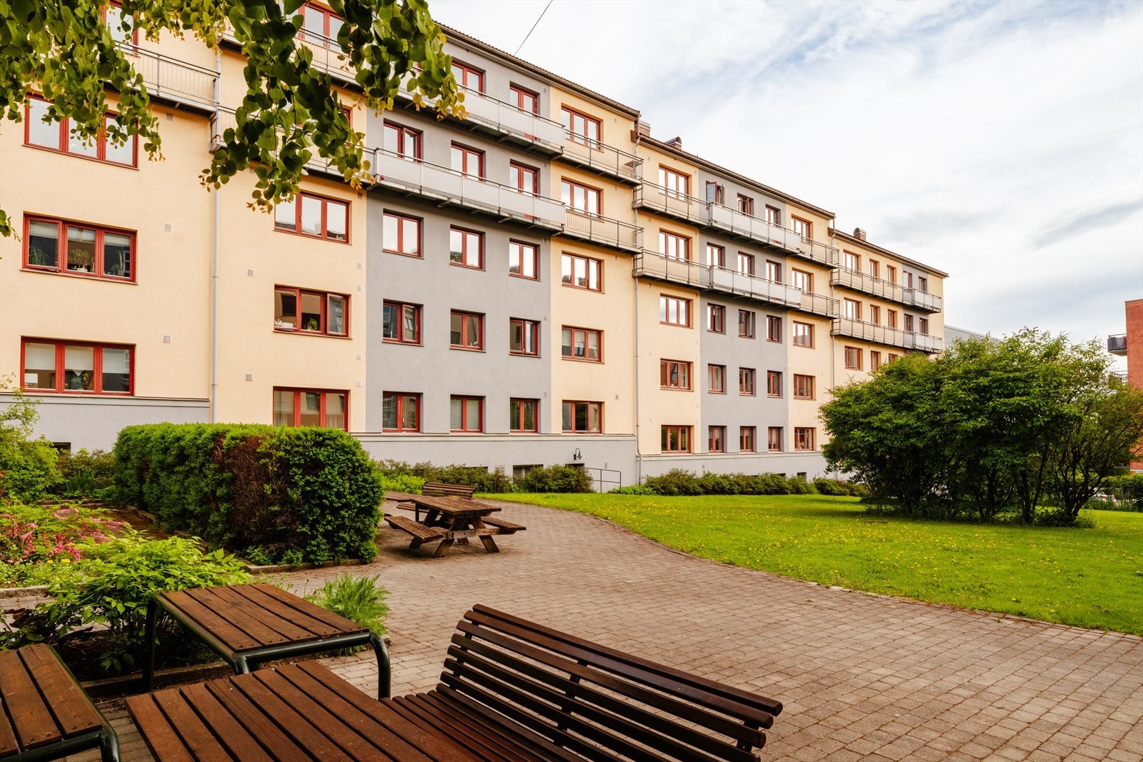 Felles uteplasser med benker og bord. Her også er det opparbeidet med busker og belegningsstein. Galleribilde