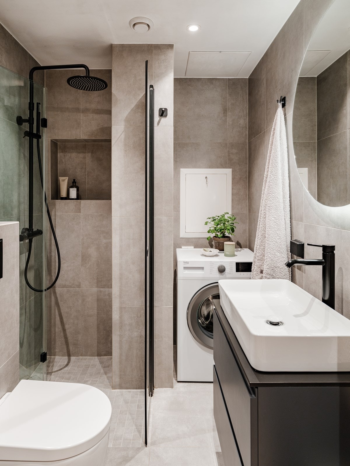 Badet har vegghengt toalett, store og moderne fliser, varmekabler i gulvet, downlights i himling og naturlig ventilasjon. Galleribilde