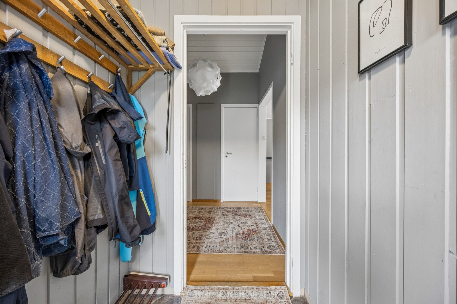 Entré med malte veggoverflater og plass til garderobe. Det er innvendig trapp mellom etasjene.