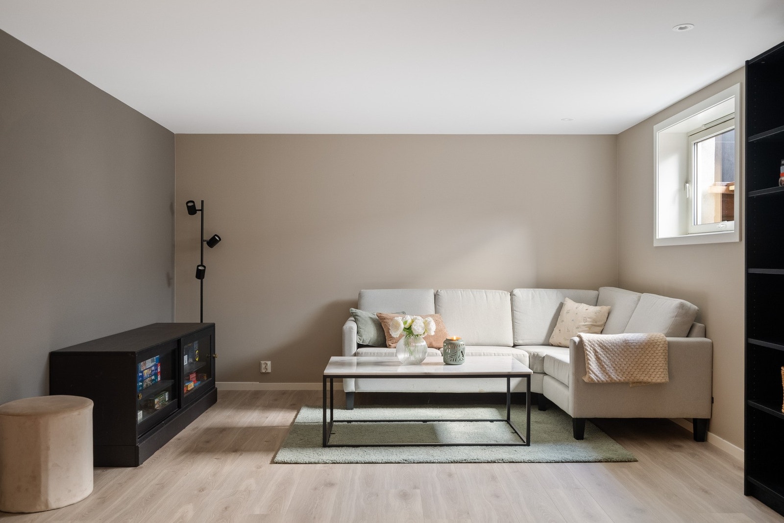 Stor kjellerstue med varme i gulv, perfekt som ungdomsavdeling eller lekestue. Vinduer og downlights sørger for et godt opplyst rom. Galleribilde