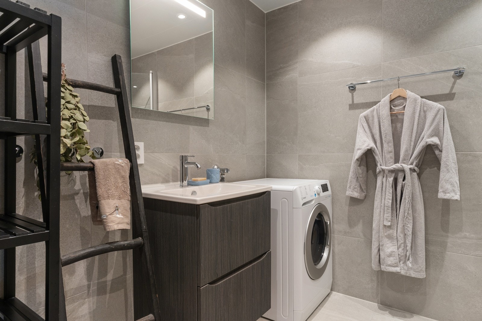 Badet har en stilren servantinnredning som gir både god oppbevaring og et elegant uttrykk.