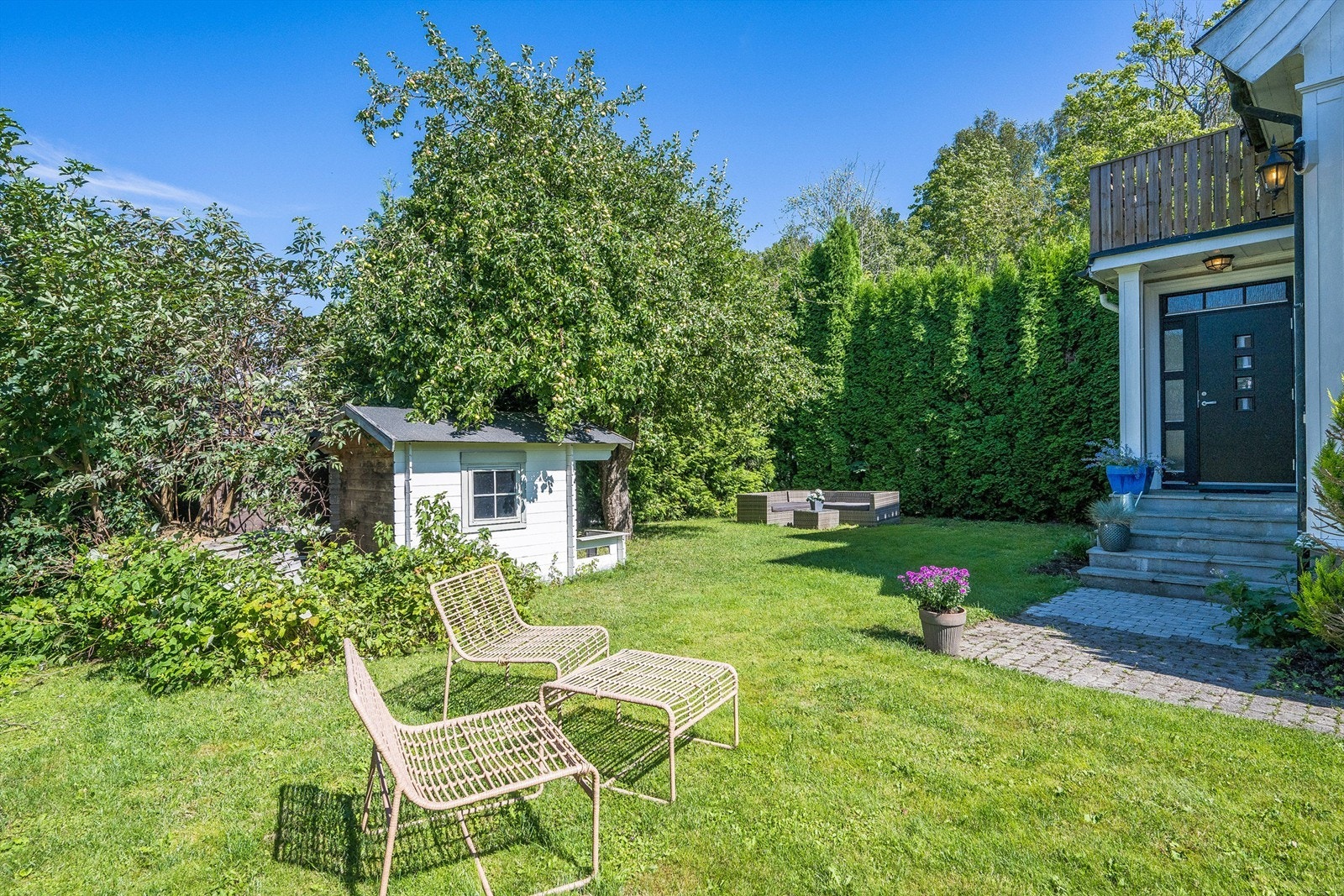 Boligen har en solrik og sjarmerende hage som er pent opparbeidet med plen, epletre og diverse beplantning. Foto: Kristian Bollæren v/Fotofinish Galleribilde