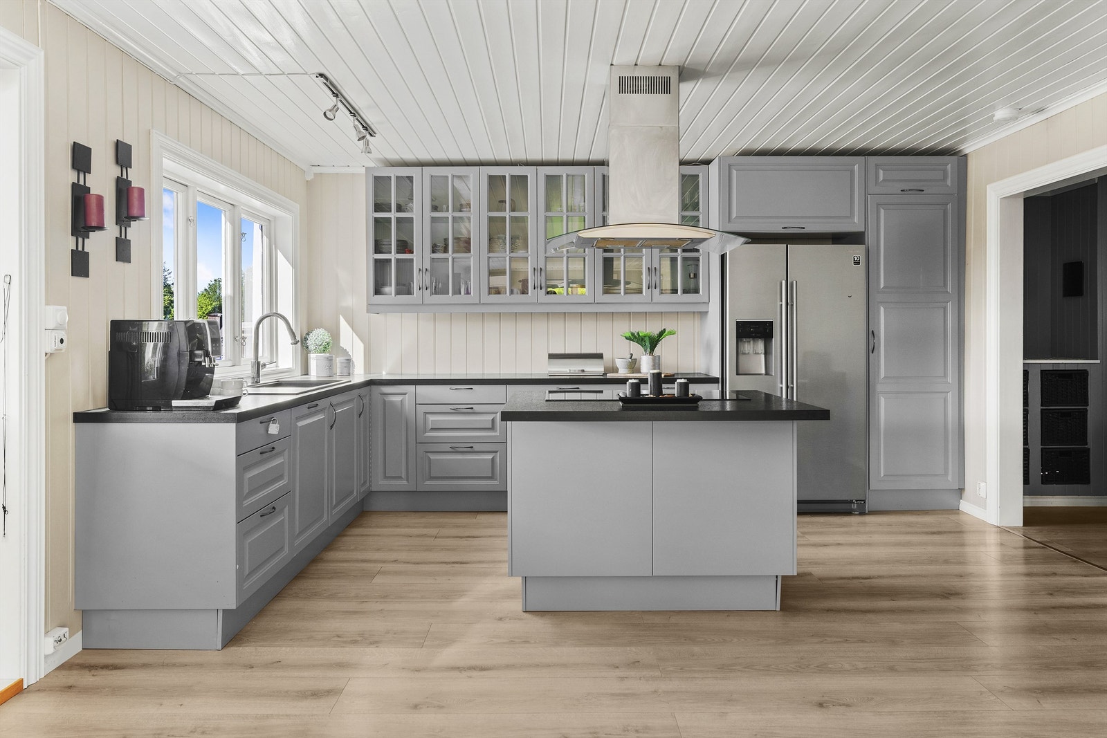 Kjøkkenet med profilerte fronter og benkeplate med laminert overflate. Integrert oppvaskmaskin, stekeovn og nedfelt platetopp på kjøkkenøy. Galleribilde