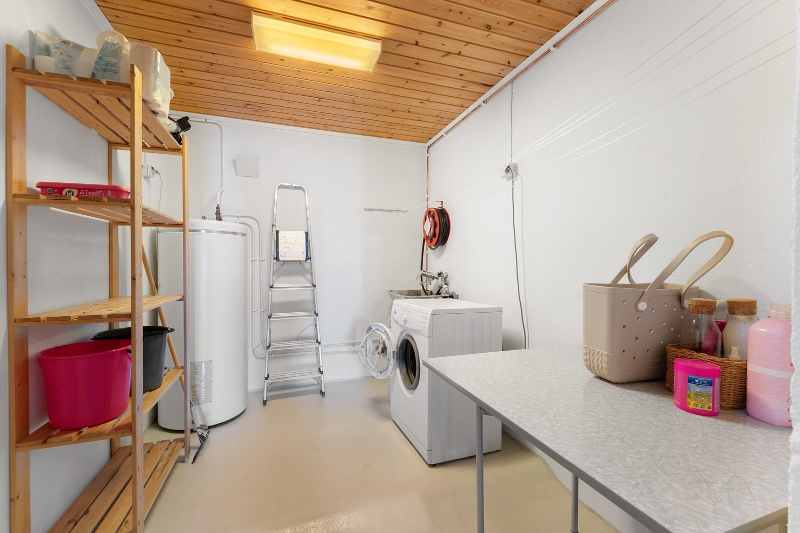 Praktisk vaskerom med god plass til tørking av klær og oppbevaring, samt opplegg for vaskemaskin og skyllekar. Galleribilde