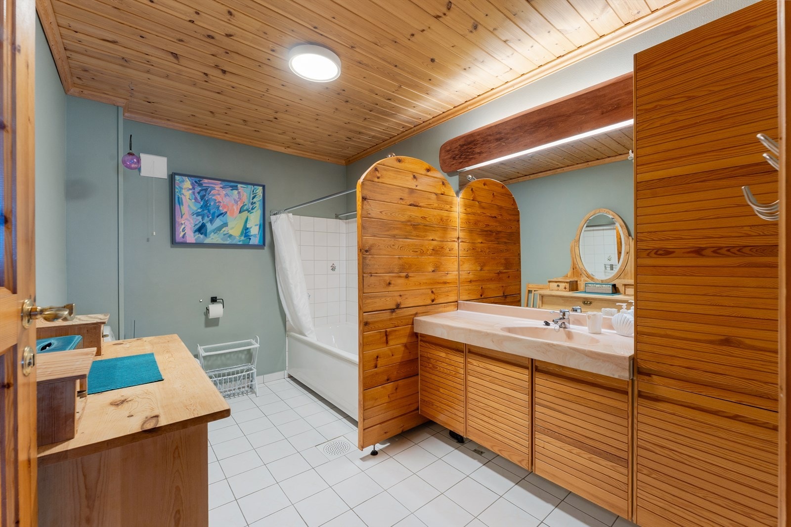 Badet er opplyst pusset opp i 1997 og har flislagt gulv med gulvvarme. Veggene har malerstrie og fliser ved badekaret, samt en praktisk skillevegg i tre. Galleribilde