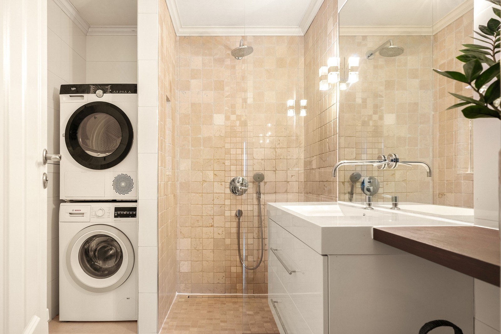 Badet er innredet med en stor dusjnisje, vegghengt toalett og servant med skuffeinnredning, speil og belysning. Galleribilde