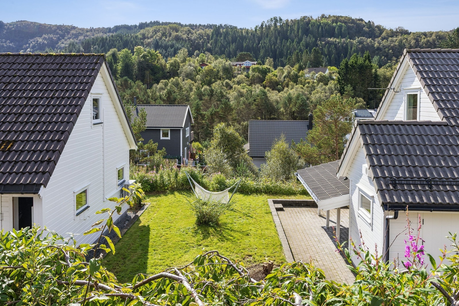 Mellom dobbelgarasjen og boligen er det en liten plen med gode muligheter til å lage seg en grønn oase. Galleribilde