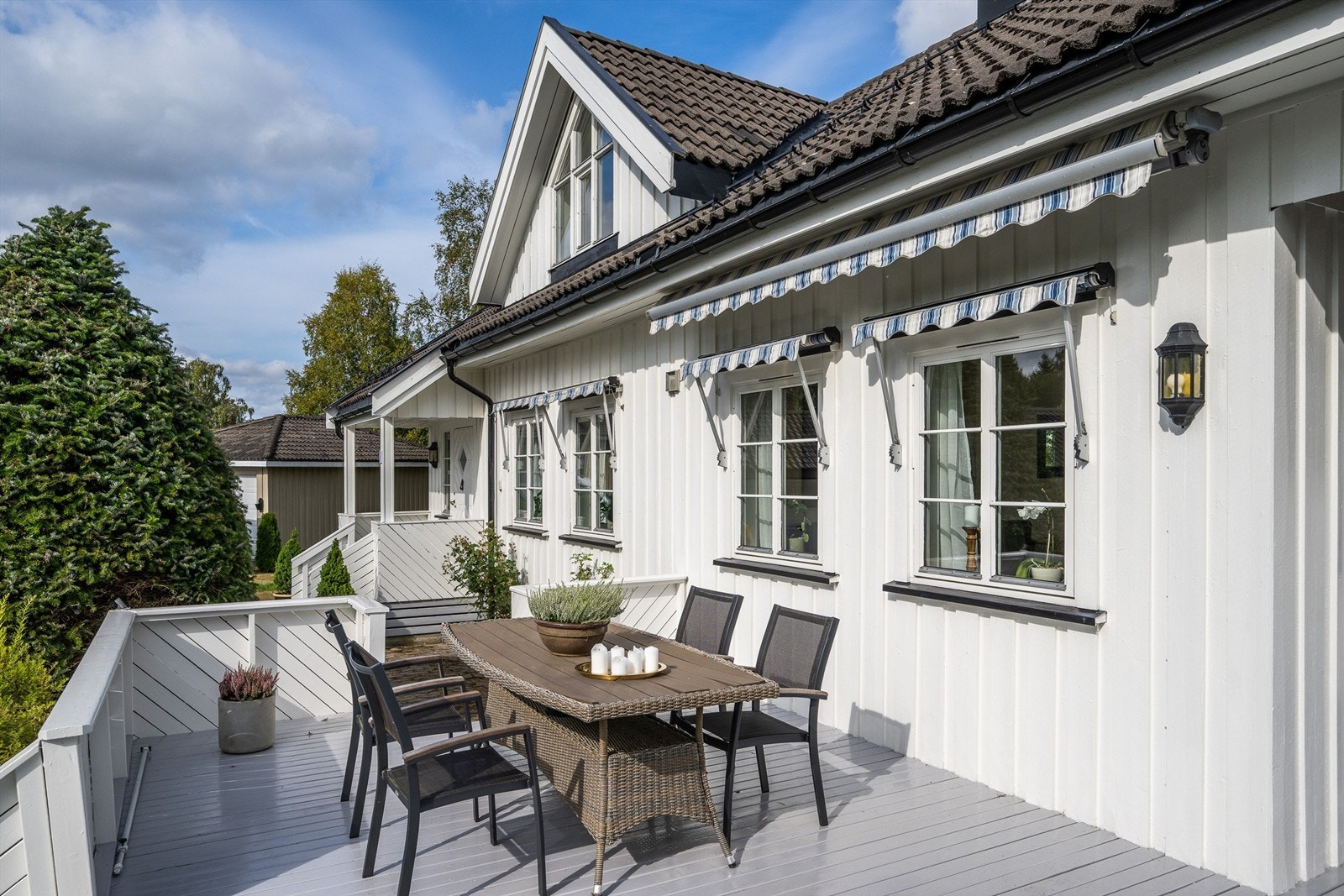 Sydvestvendt terrasse med utgang fra stuen, utstyrt med markiser og god plass til utemøbler. Galleribilde