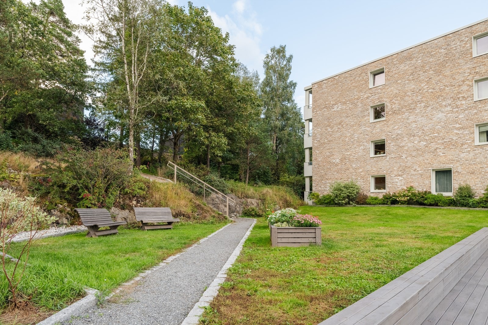 Sameiet har pent opparbeidede fellesarealer med sittegrupper og beplantning Galleribilde