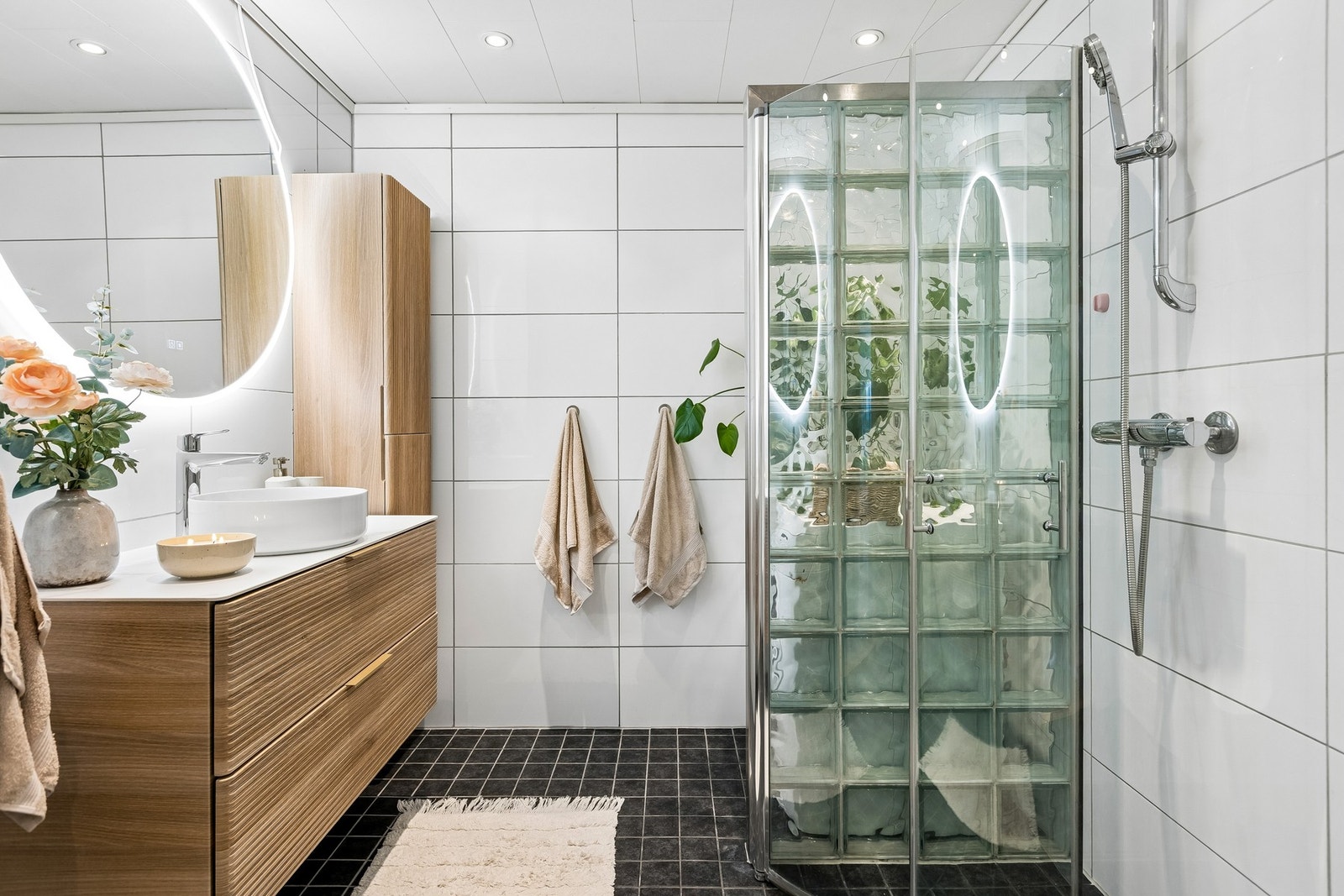 Badet måler 6 kvm, og er lagt med flis på gulv og vegger, samt gulvvarme og downligts i himling. Galleribilde