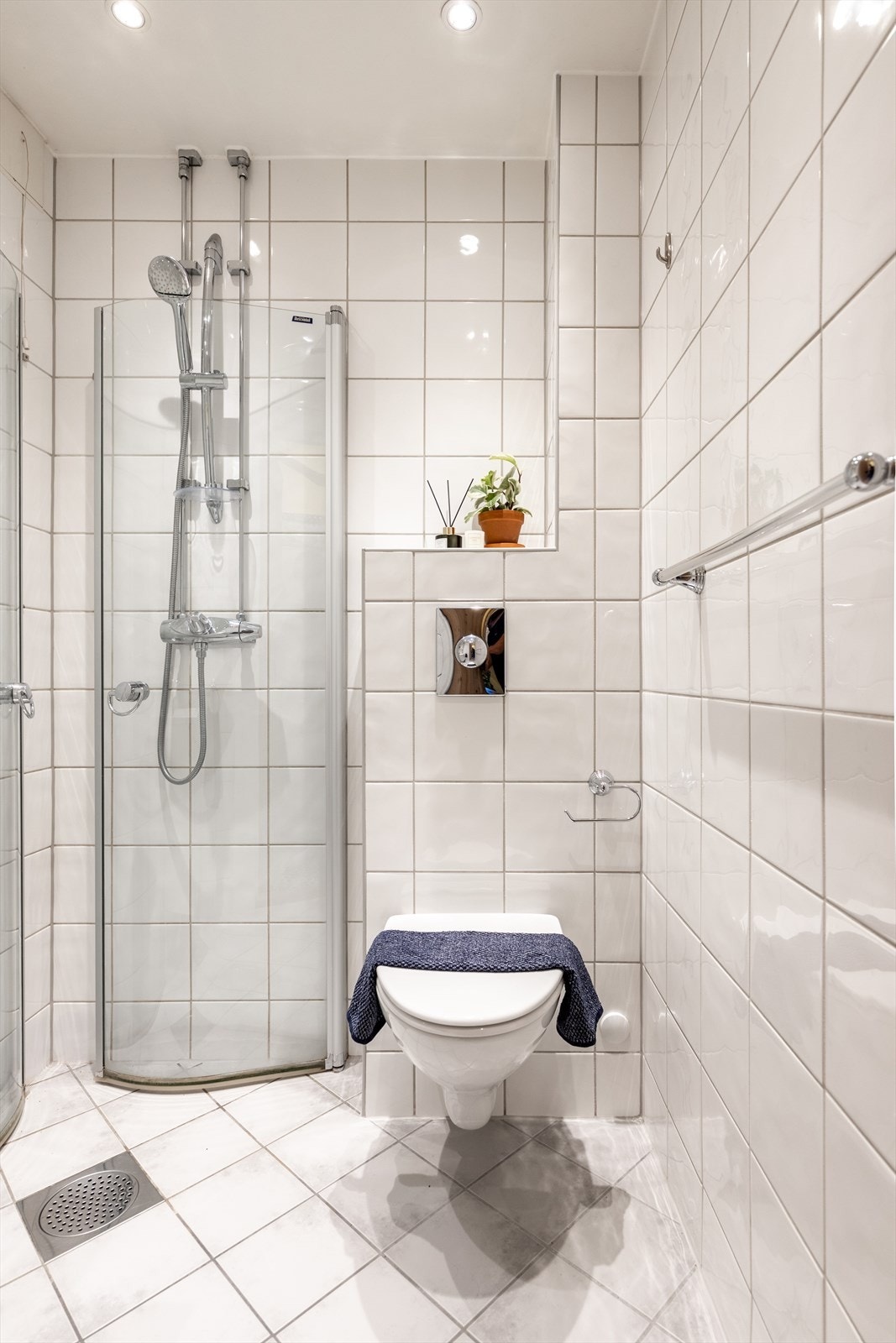 Varmtvann er inkludert i felleskostnadene. Badet er utstyrt med dusjhjørne, veggmontert wc og servantskap Galleribilde
