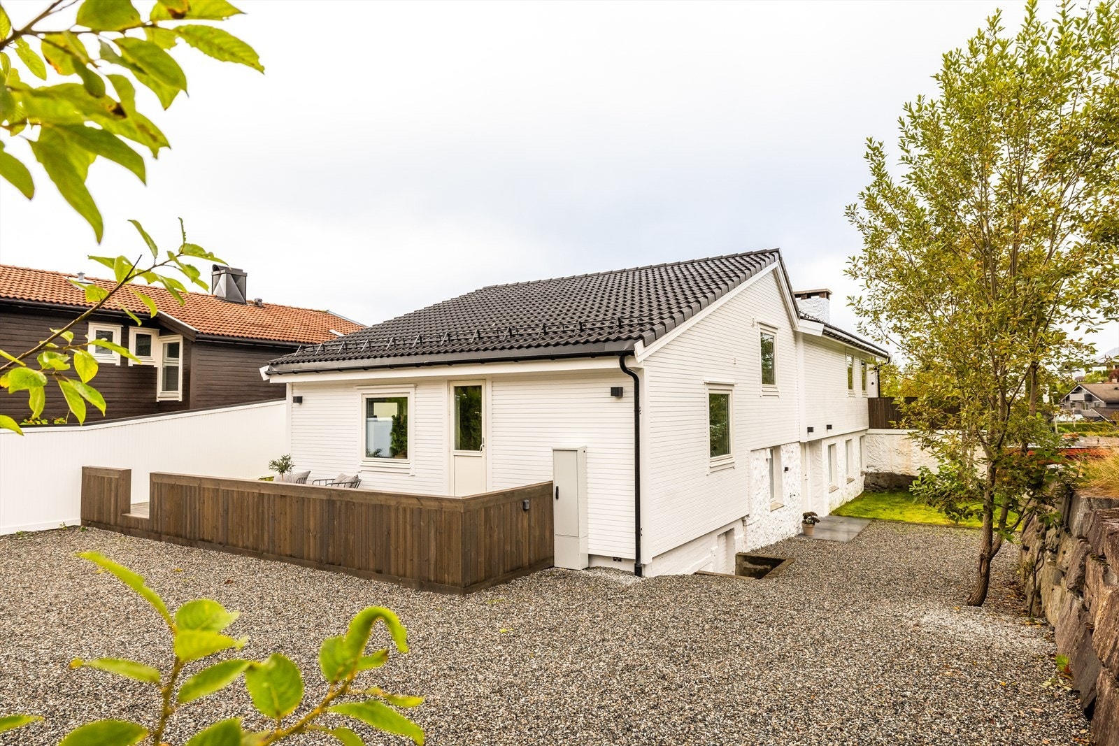 Tomtearealet er pent opparbeidet med singel, plen, murer og beplantning. Galleribilde