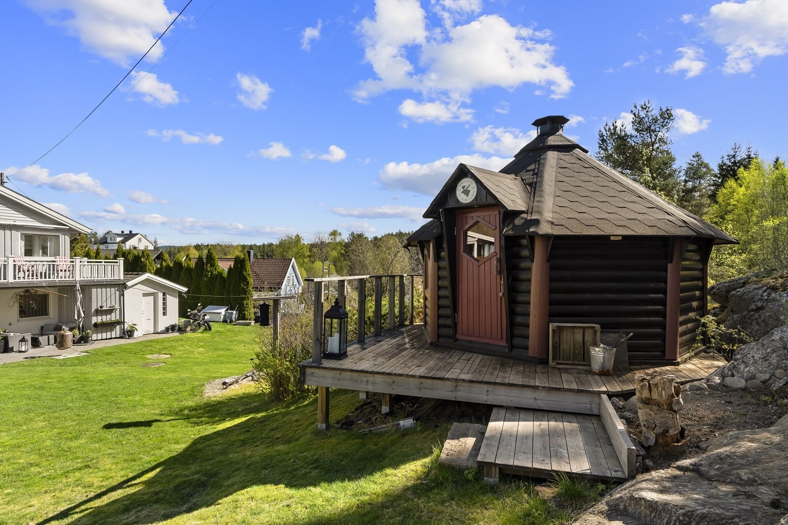 Frittstående grillbu flott plassert på tomten med hyggelig utsyn over hage og omkringliggende naturomgivelser. Galleribilde