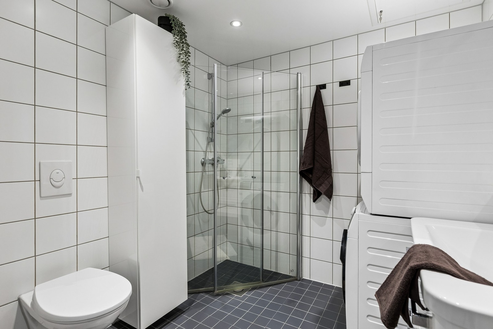 Badet er utstyrt med innfellbare dusjdører og vegghengt toalett. Galleribilde