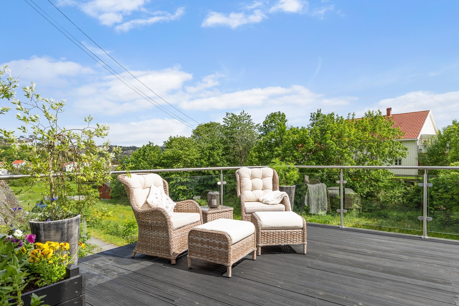 Terrassen over garasjen har terrassedekke i tre og glassrekkverk Galleribilde