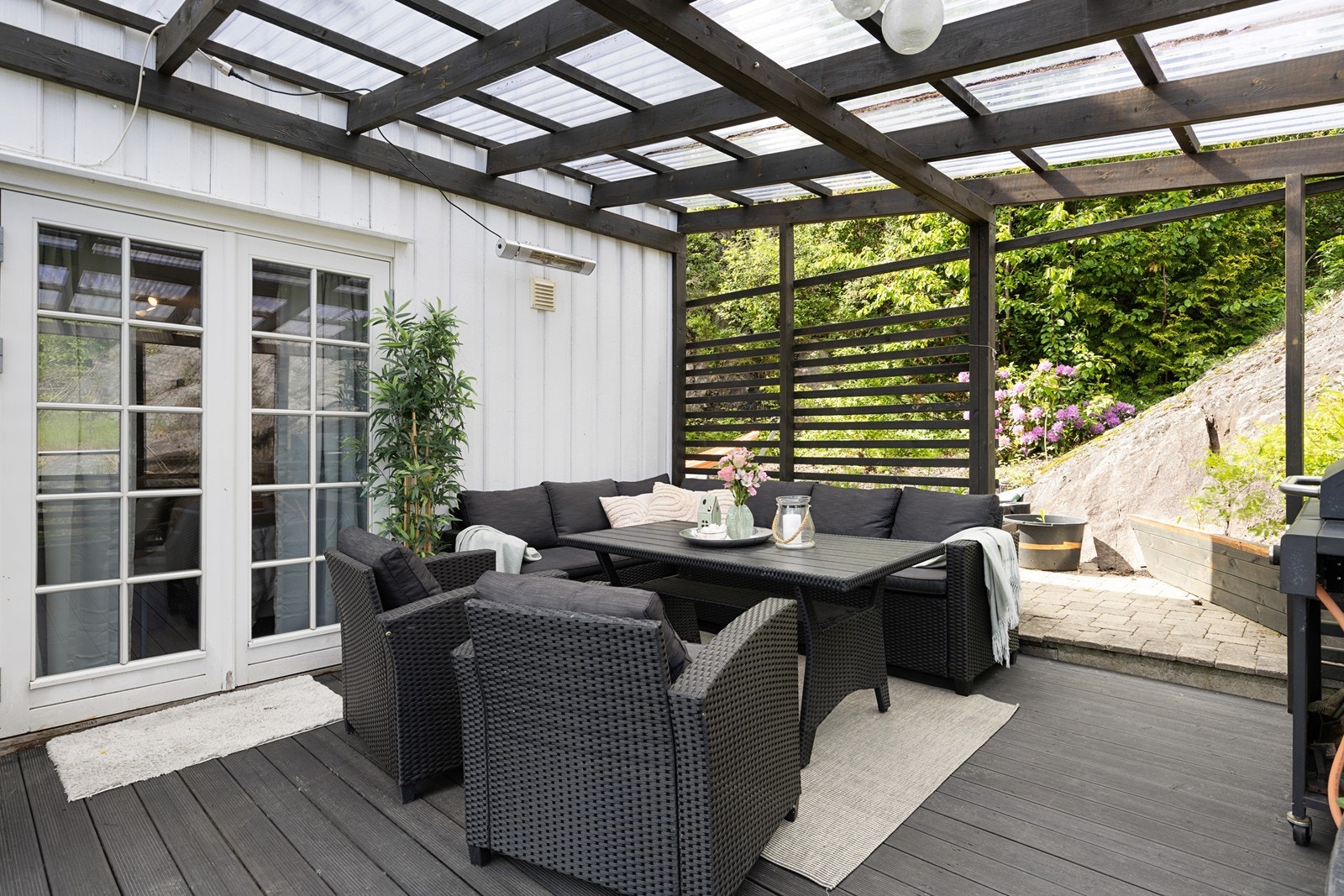 Terrassen utenfor hovedsoverommet har god plass til grill og sittegruppe under tak, med adkomst videre til bakhagen. Galleribilde