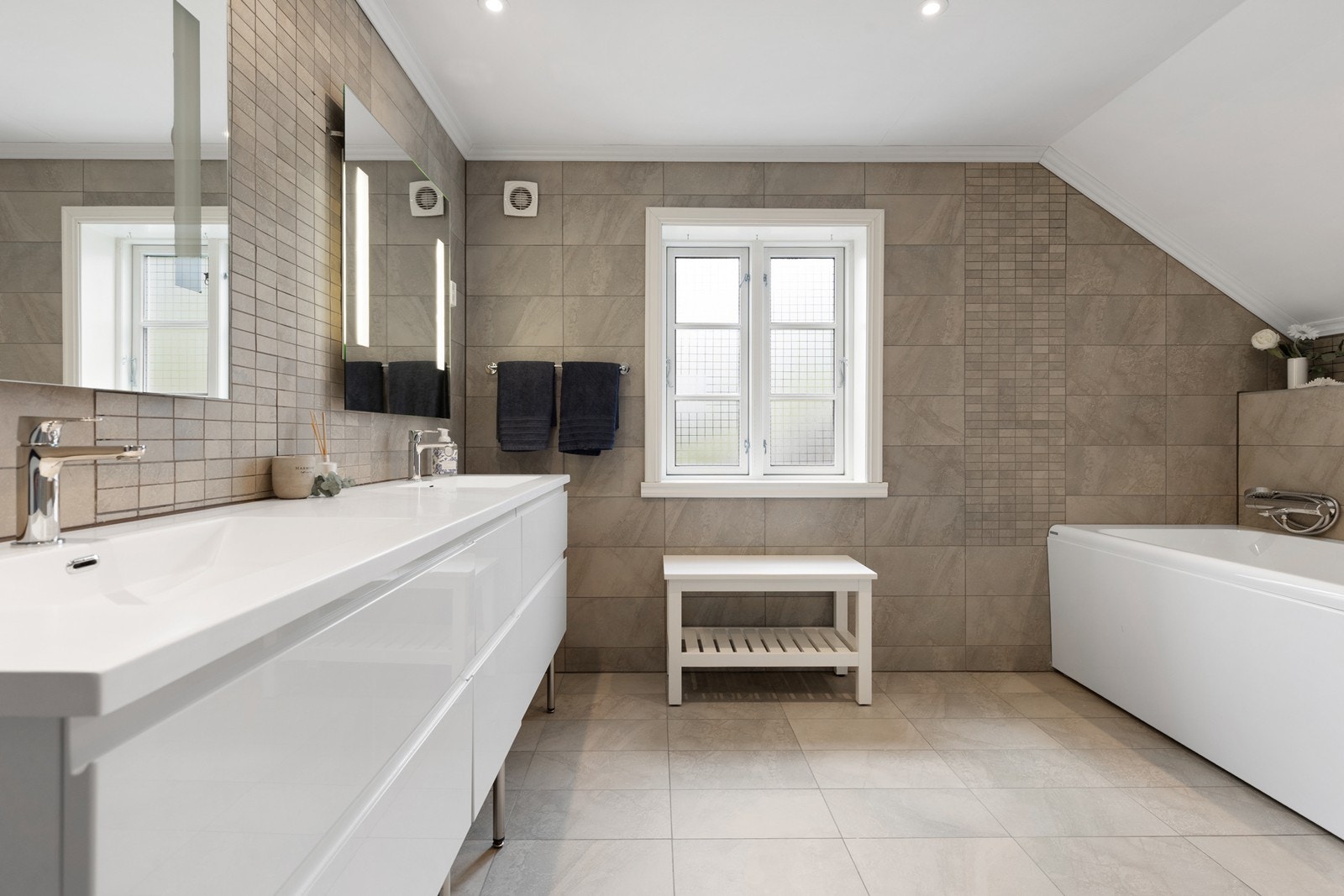 Flislagte vegger og gulv gir badet et solid og vedlikeholdsvennlig grunnlag. Galleribilde