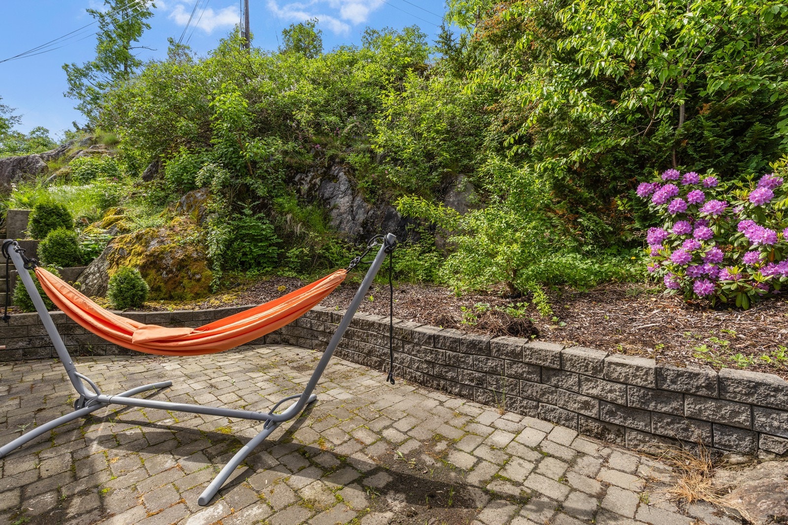 Bakhagen har opparbeidet uteområde med belegningsstein, støttemur og beplantning. Galleribilde