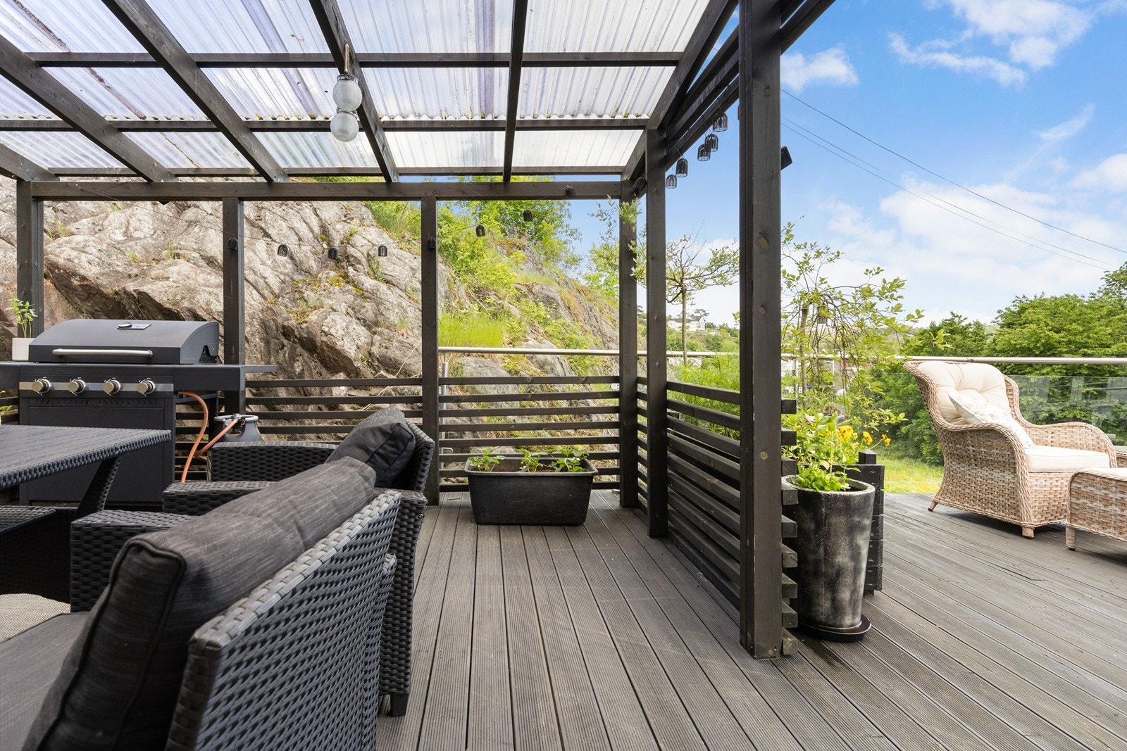Terrassen utenfor hovedsoverommet har plassbygget pergola med tett tak for bruk i alle typer vær Galleribilde