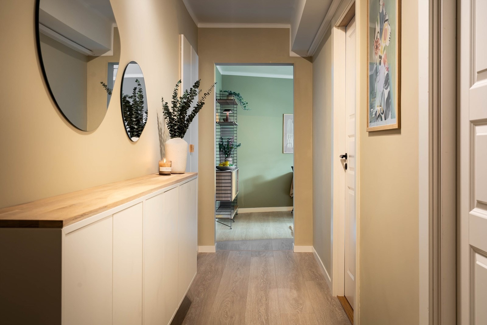 Her møter du en ryddig og hyggelig entré som gir et fint førsteinntrykk av boligen. Med plassbygde skap og veggmontert oppbevaring tar hånd om det du ønsker å ha ute av syne. Galleribilde