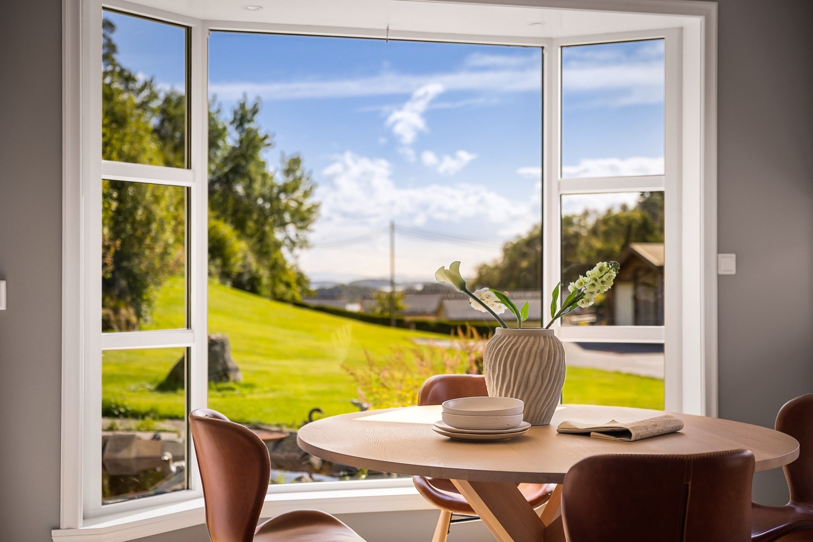 Fra spiseplssen har man full oversikt over tunet og utsikt til Raunefjorden og Austevoll. På kveldstid kan man skimte lysene fra vindmøllene på Fitjar. Galleribilde