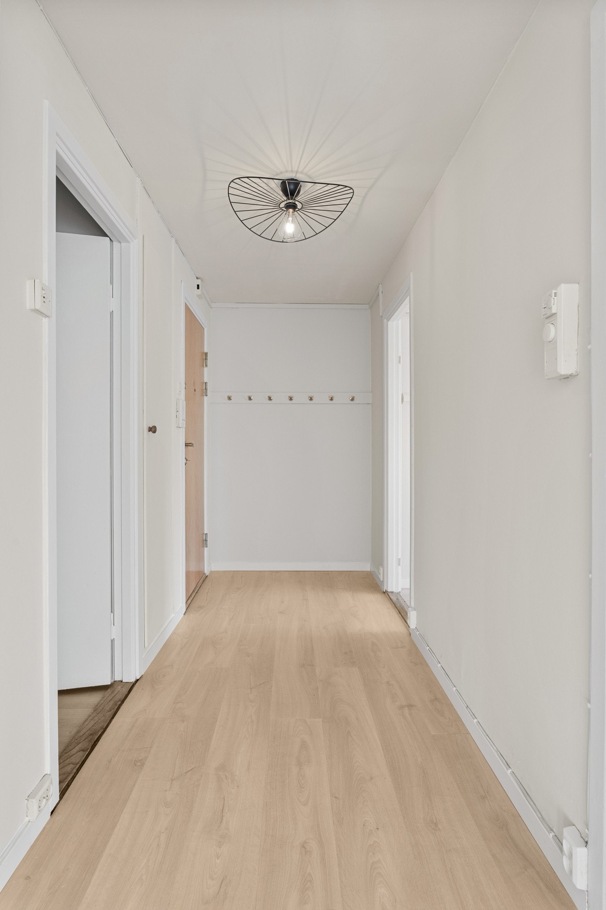 Vel inne blir vi ønsket velkommen i en entré med lyse veggflater, laminatgulv og dørcalling. Galleribilde
