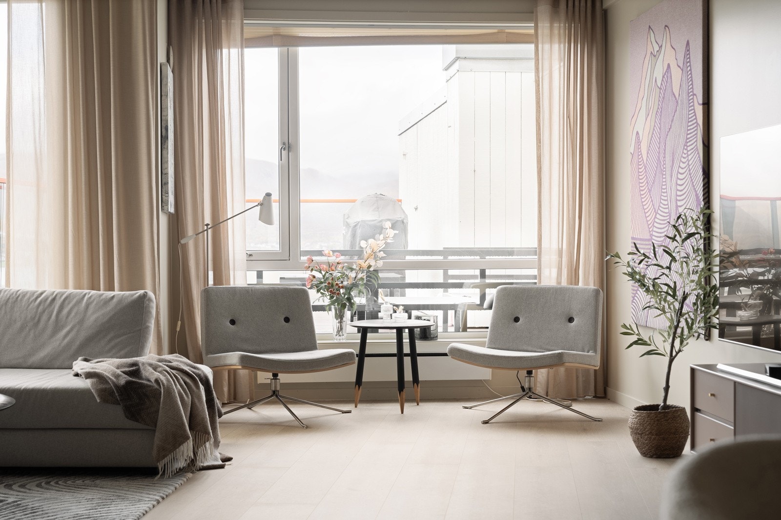 Lys og innbydende stue med store vindusflater.