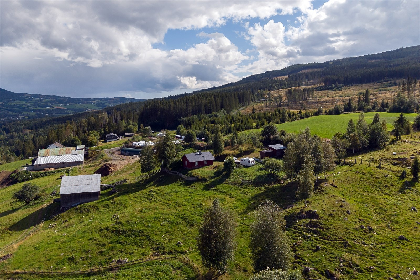 Oversikt over tunet med våningshus, garasje, utedo/bod og uteløe. Galleribilde