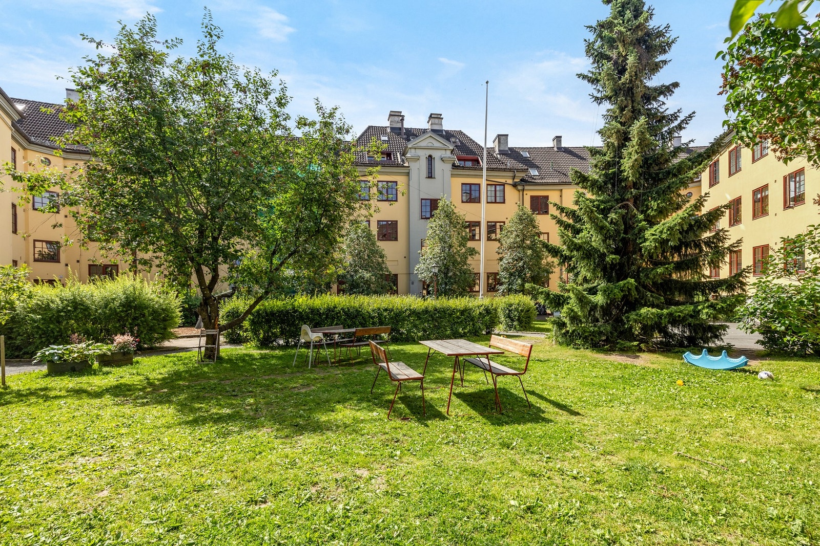 Bakgården er pent opparbeidet med planter, blomster og benker Galleribilde