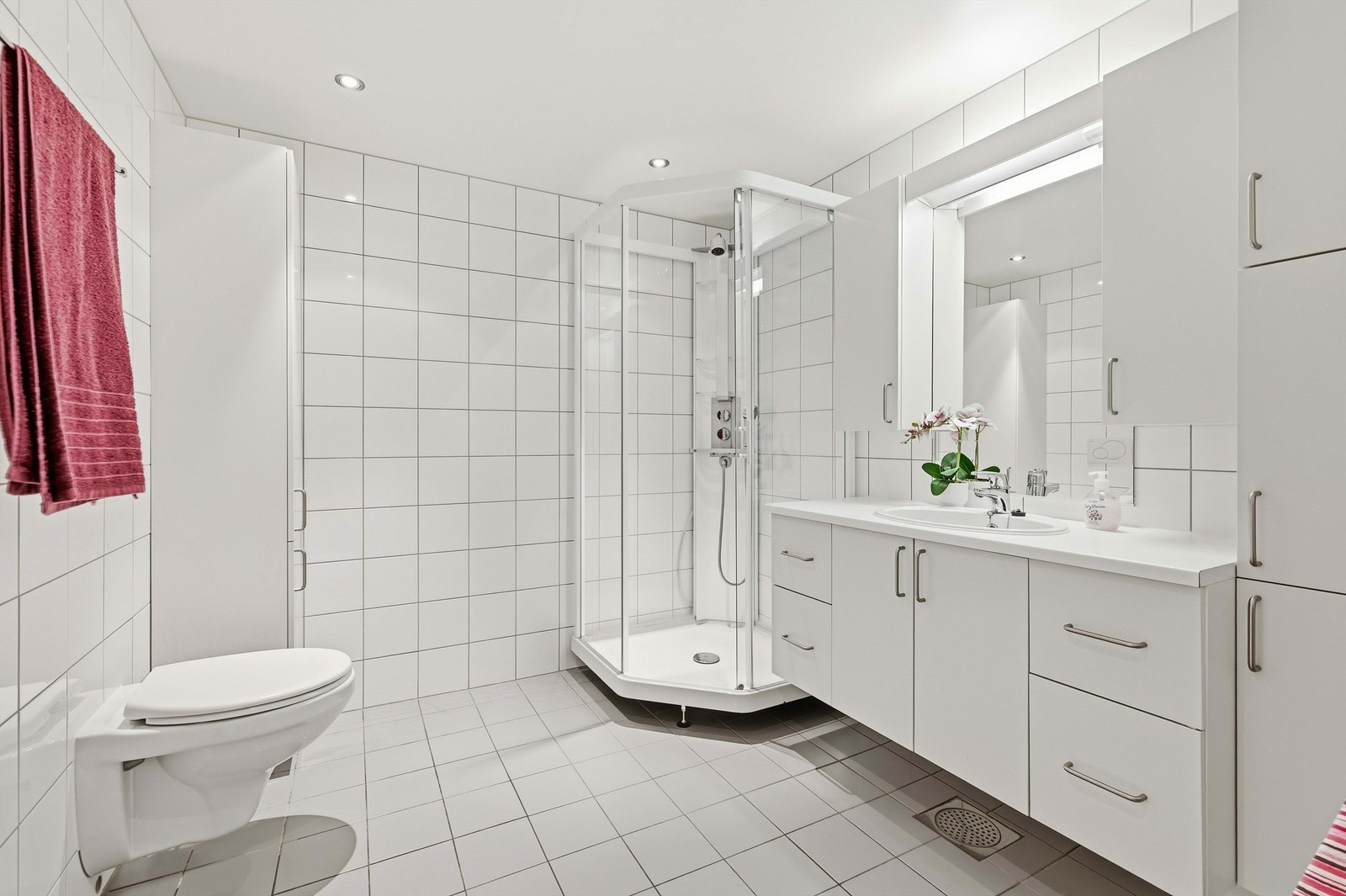 Leiligheten har et romslig bad/wc med klassiske hvite fliser og tidløs baderomsinnredning med svært god plass for det som trengs på et baderom Galleribilde