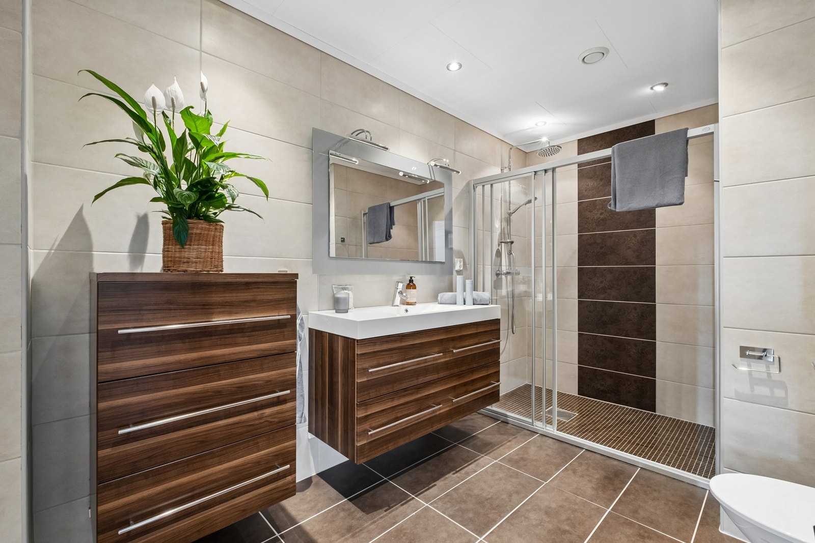 Det helflisede badet har varmekabler i gulvet og downlights som gir behagelig belysning. Galleribilde