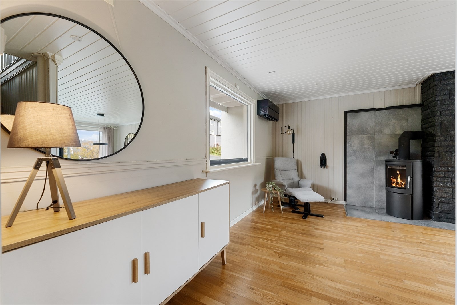 Romslig og innbydende stue med vedfyring, gode lysforhold og en luftig romfølelse som skaper en varm og hyggelig atmosfære. Galleribilde