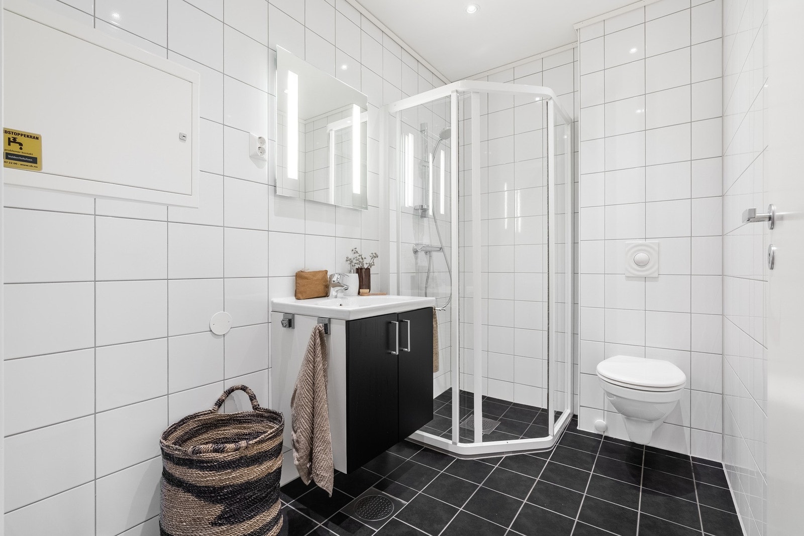 Det andre badet ligger i nær tilknytning til hovedsoverommet og fungerer som et komfortabelt hverdagsbad. Også her er det helflisede overflater, dusj, vegghengt toalett, servant og varme i gulvet. En praktisk og privat plassering, godt adskilt fra boligen Galleribilde