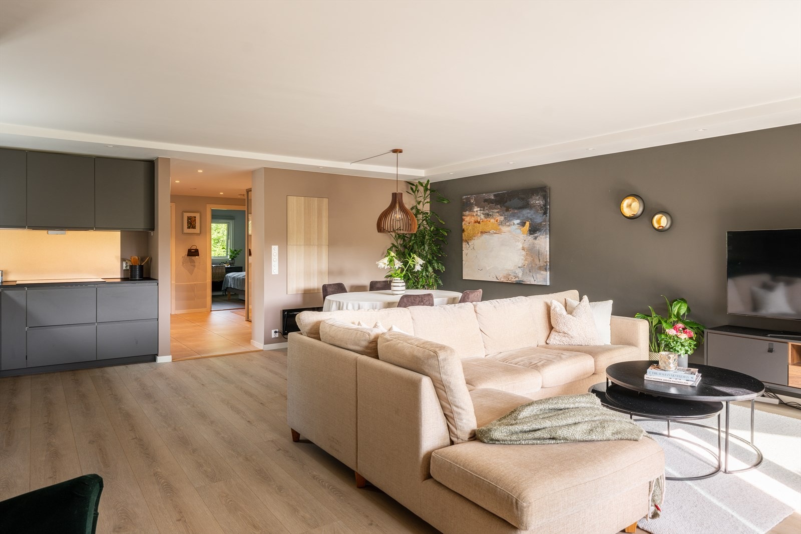 Stuen ligger i åpen løsning til kjøkkenet og deles naturlig inn i to soner, med god plass til tv-lounge i den ytterste delen og stort spisebord nærmest kjøkkensonen. Galleribilde