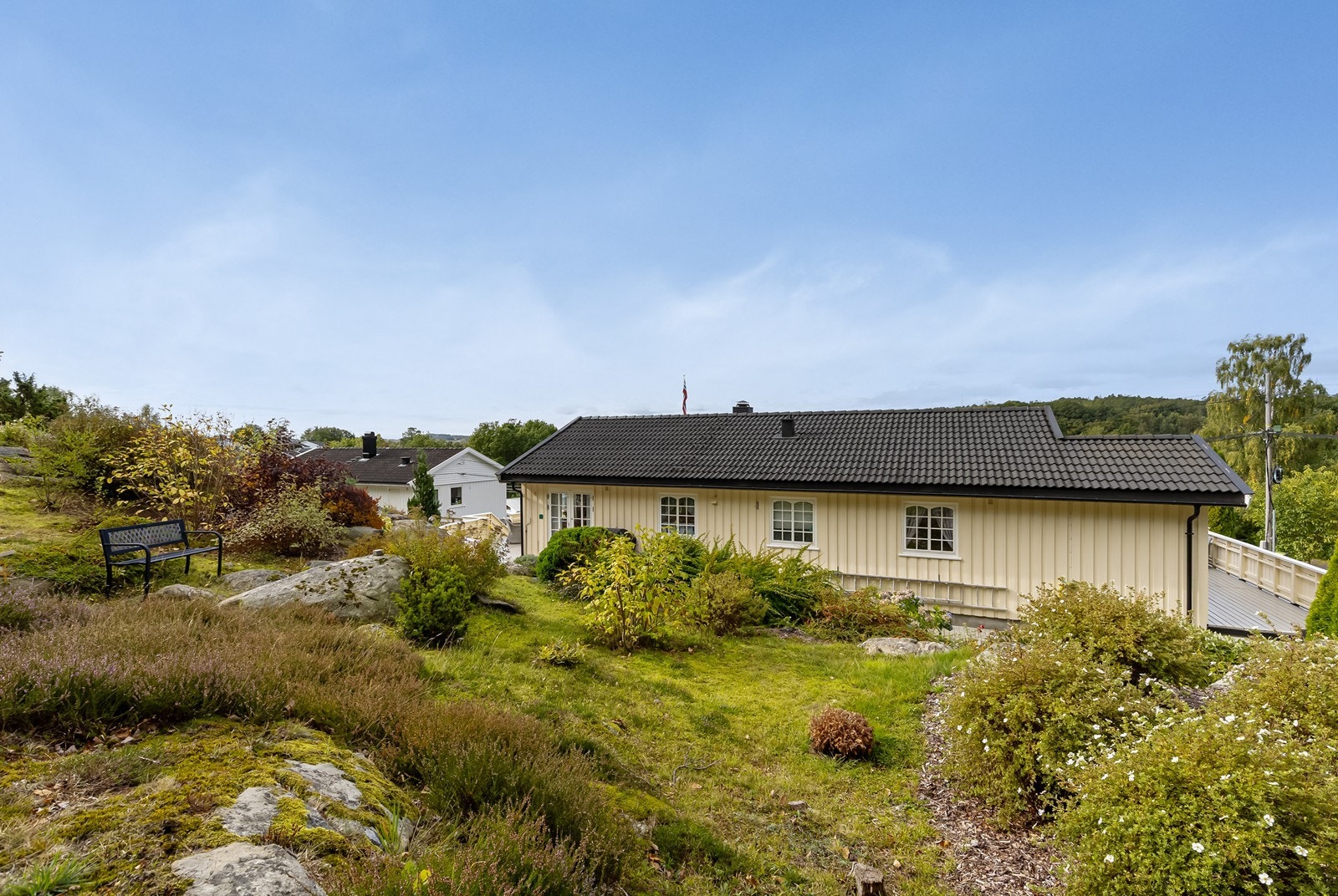 Naturtomten er pent opparbeidet med variert beplantning og flere hyggelige steder å slå seg ned. Galleribilde
