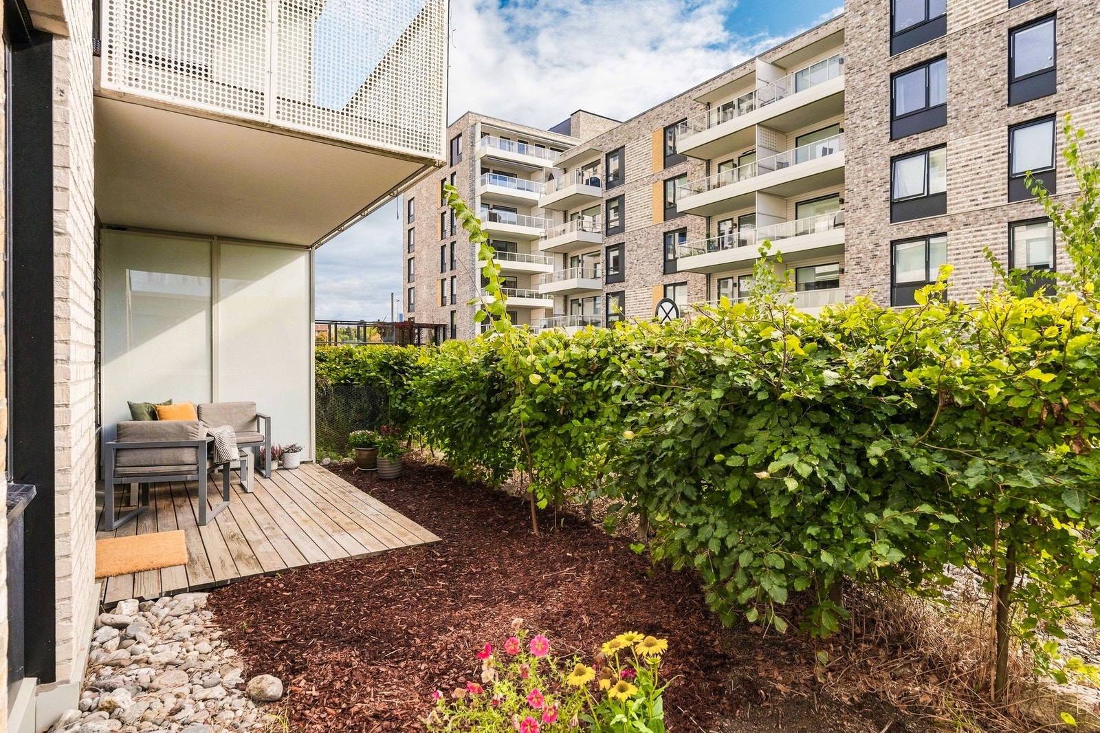 Stor hekk som sørger for lite innsyn til boligen og uteplass. Galleribilde