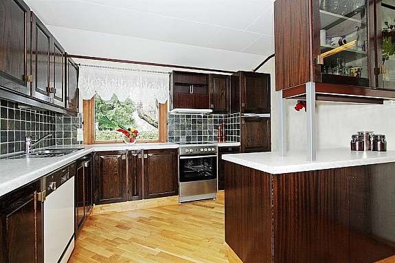 Kjøkkeninnredningen - rikelig med skaper og vindu mot gårdsplasssen. Galleribilde