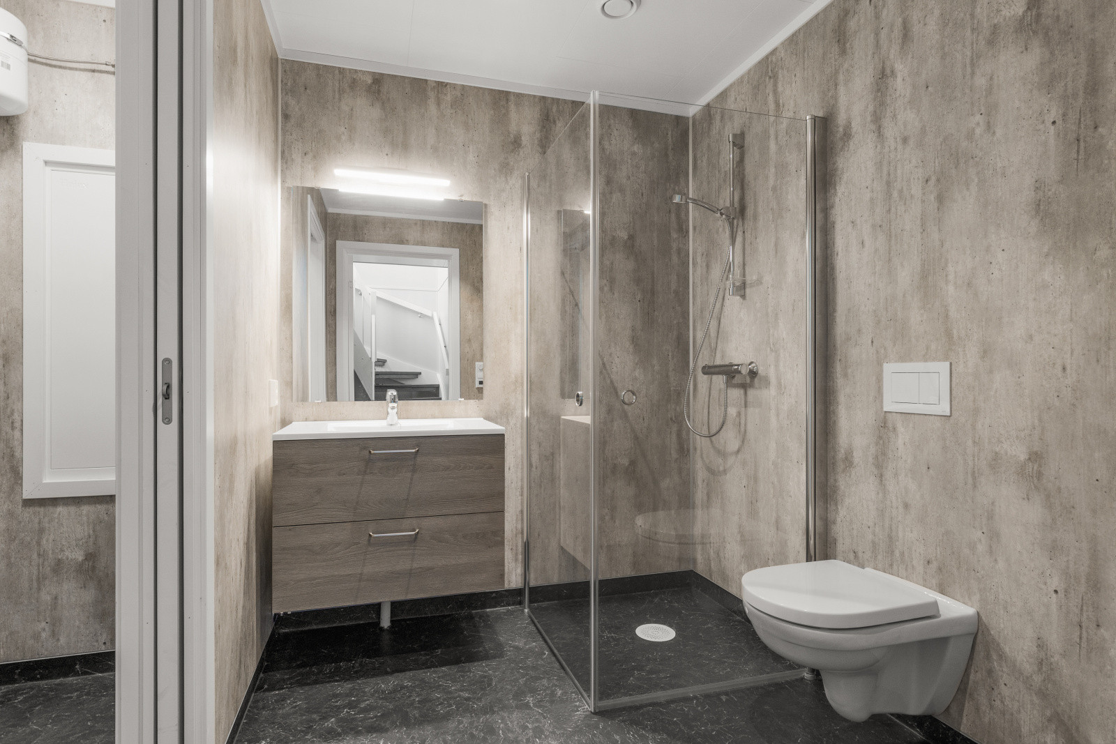 Baderom med stilrent design fra Nygård, dusjhjørne og vegghengt toalett  – alt du trenger på ett sted.