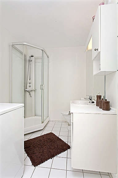 Lyst og pent bad/wc. Flislagt på gulv og i dusjhjørne bak dusjkabinett. Varmekabler i gulv. Opplegg til vaskemaskin. Galleribilde