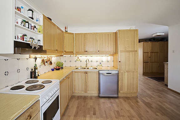 Kjøkkeninnredning med furufronter fra byggeåret. Godt med skap- og benkeplass. Galleribilde