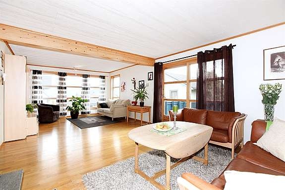 Romslig stue med store vindusflater Galleribilde