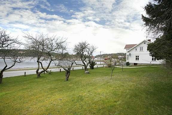 Eiendommen er pent opparbeidet med gressplen Galleribilde