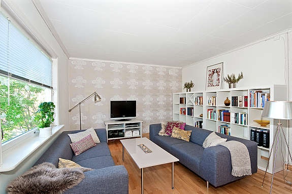 Stuen har parkett på gulv, malt tapet og tapet på vegger og plater i tak. Galleribilde