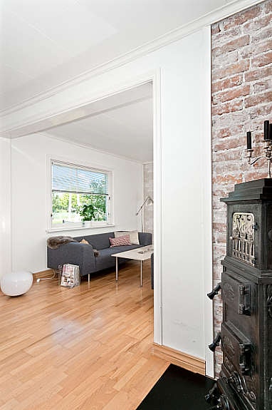 Stilig eldre vedovn med tegelsteinsmur. Galleribilde