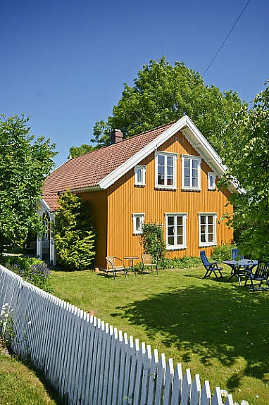 Nydelig 'gammeldags' hage med hvitt stakittgjerde som omkranser boligen. Galleribilde