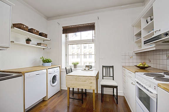 Meget pen foliert innredning med hvite skapfronter. Fliser over benk. Galleribilde