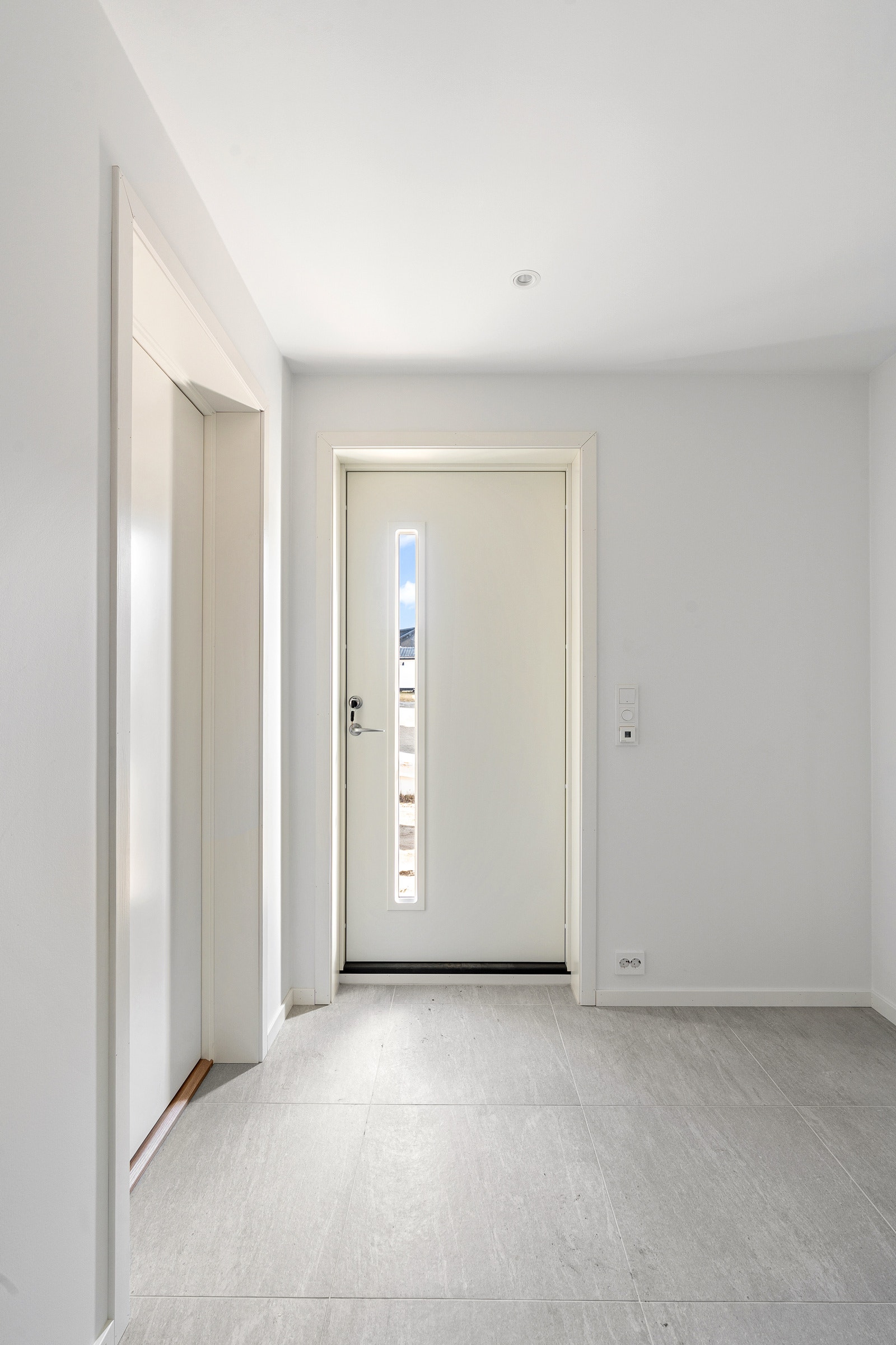 Velkommen inn. Flislagt gulv med varmekabler i vindfang.