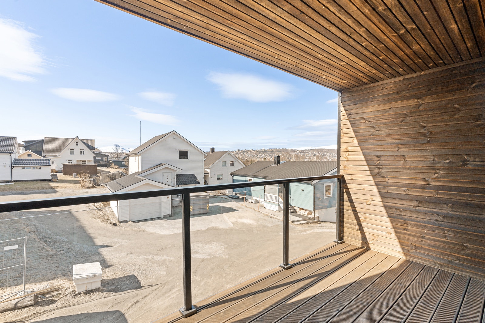 Utgang til Sørvestvendt takoverbygd balkong med glassrekkverk.